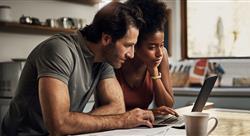 Couple with a laptop doing finance paper work together at home. 