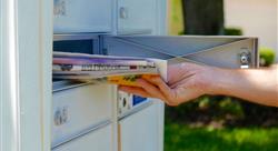 hand pulling stack of mail out of mailbox