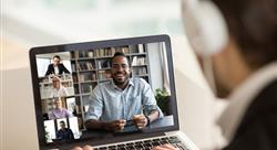 Back view of male employee talking on video call with diverse smiling colleagues