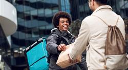 restaurant delivery man handing an order to a customer in the city