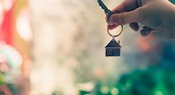 hand holding key with a house keychain