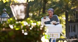 woman smiling at a personalized postcard