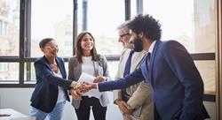 our business associates meeting in a conference room, smiling and shaking hands