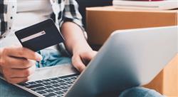 a laptop user holding a credit card